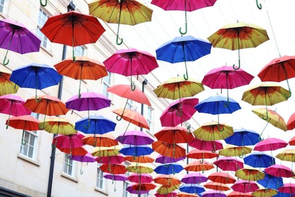 cool art installation of primary colored umbrellas hanging over a street